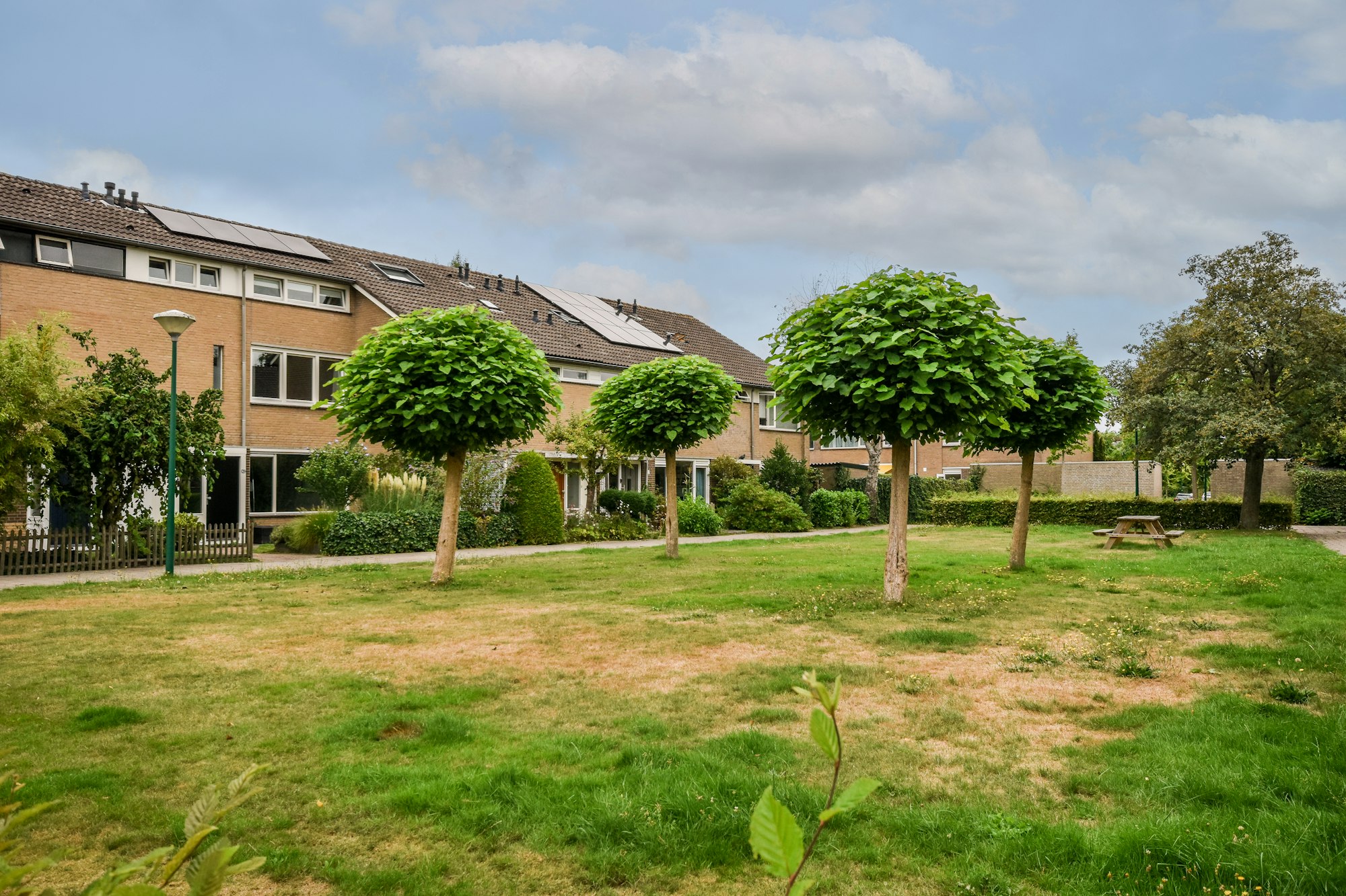 Simple patio with vegetation inside and playground with swings